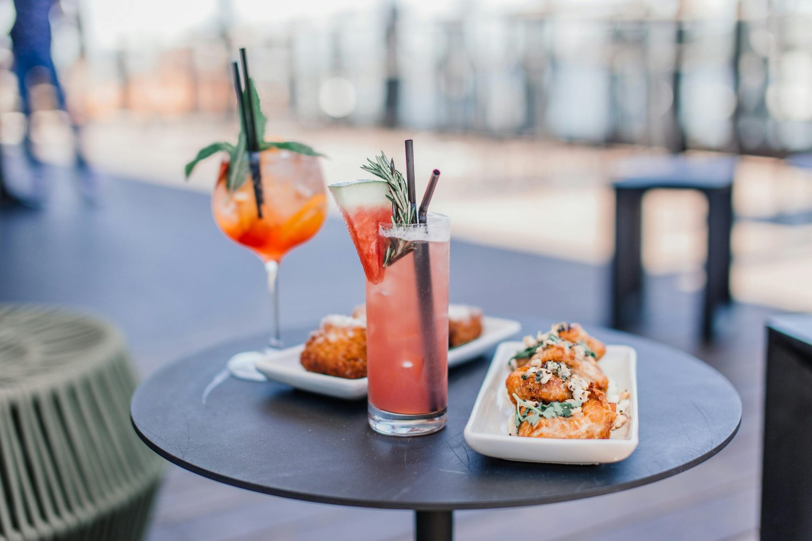 A scenic rooftop bar featuring two cocktails with summer vibes. Watermelon garnishes in lovely Airlie Beach Bar.