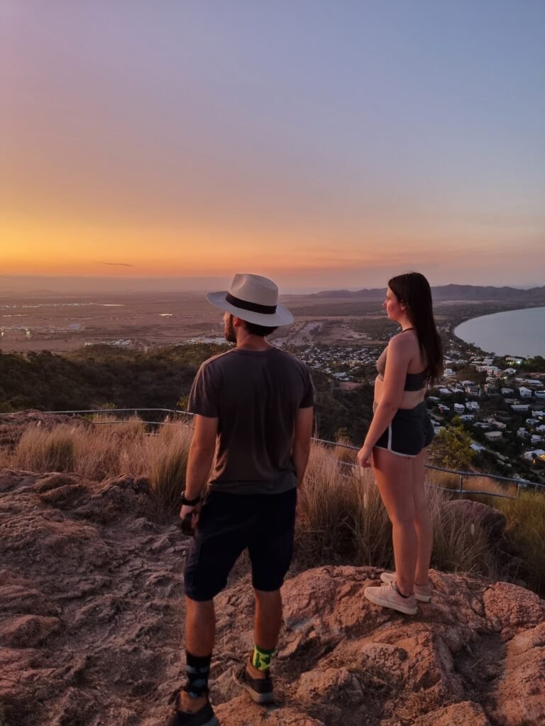 Two hikers on top of Castle Hill in Townsville Queensland at sunset